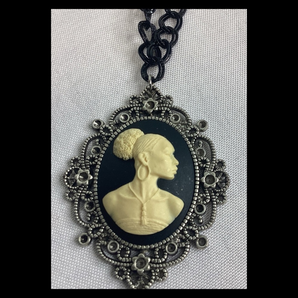 Cream lady, cameo black background with a black chain.
